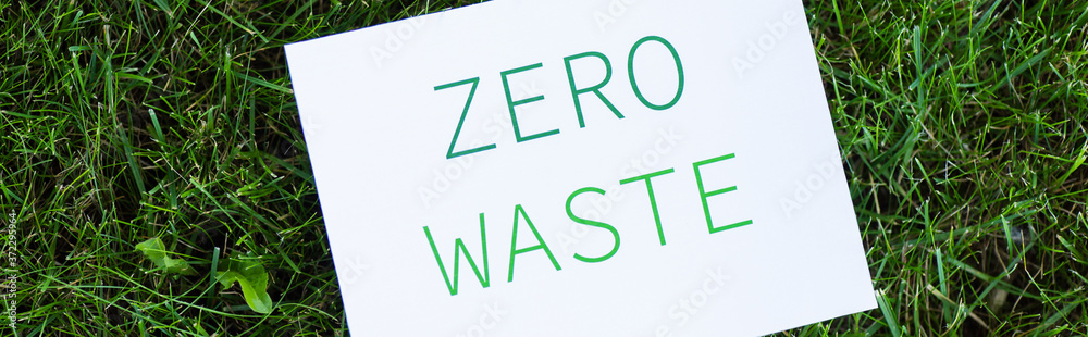 Horizontal concept of card with zero waste lettering on grass outdoors, ecology concept Horizontal concept of card with zero waste lettering on grass outdoors, ecology concept