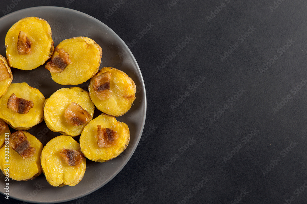 Baked potatoes with lard, a strata-fast delicious lunch, in a plate on a stone table. Copy space. Baked potatoes with lard, a strata-fast delicious lunch, in a plate on a stone table. Copy space.