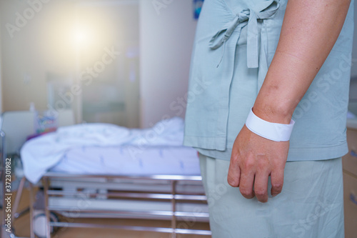 soft focus Patients man quotes in hospital standing by the bed of a ill sick person, patient rests and saline solution tube intravenous iv drip inserted and stand waiting for the doctor to come check.