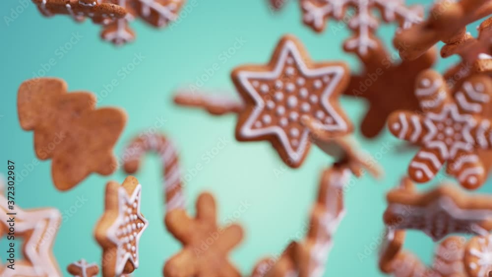 3d Christmas biscuits in the shapes of snowflakes and stars with icing, gingerbread cookies falling and rotating, isolated on blue background. Holiday animation with motion blur