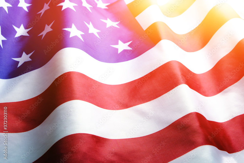 Fototapeta premium Flag United States of America in bright rays sun.