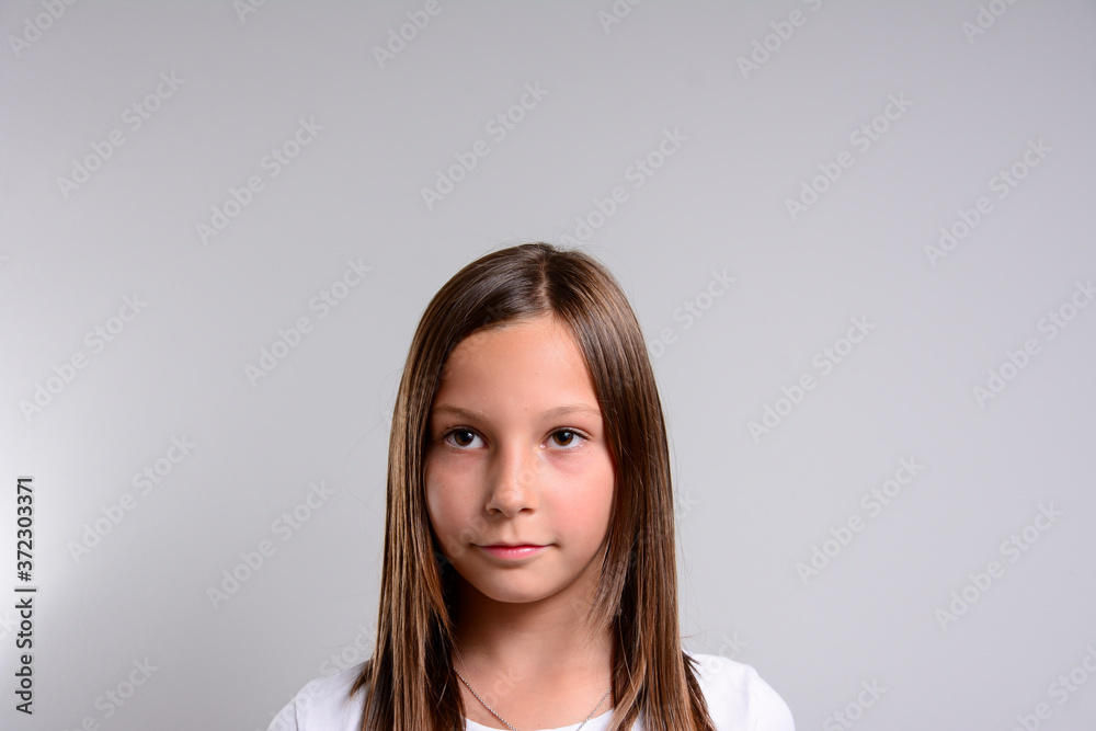 Young girl standing over isolated grey background happy face smiling looking at the camera. Positive person. Copy space for text. Young girl standing over isolated grey background happy face smiling looking at the camera. Positive person. Copy space for text.