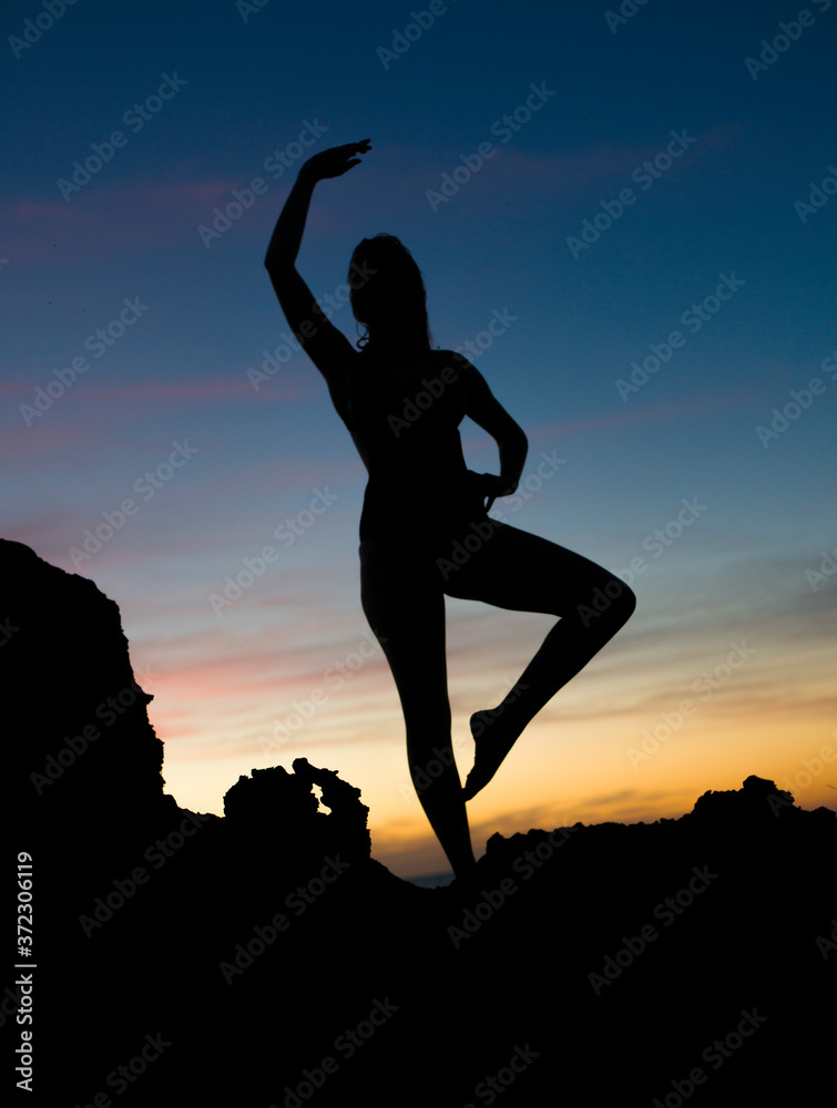 silhouette of a woman posing sunset beach