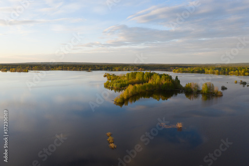 Spring flooding on the river, flooded forest, islands on the river. View from a drone, a bird's-eye view. View without the presence of people in the evening. 