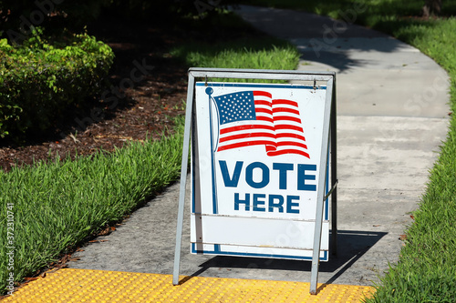VOTE HERE SIGN placed on the walkway to a neighborhood polling place, as seen on election day in Fort Lauderdale, Florida, USA. 