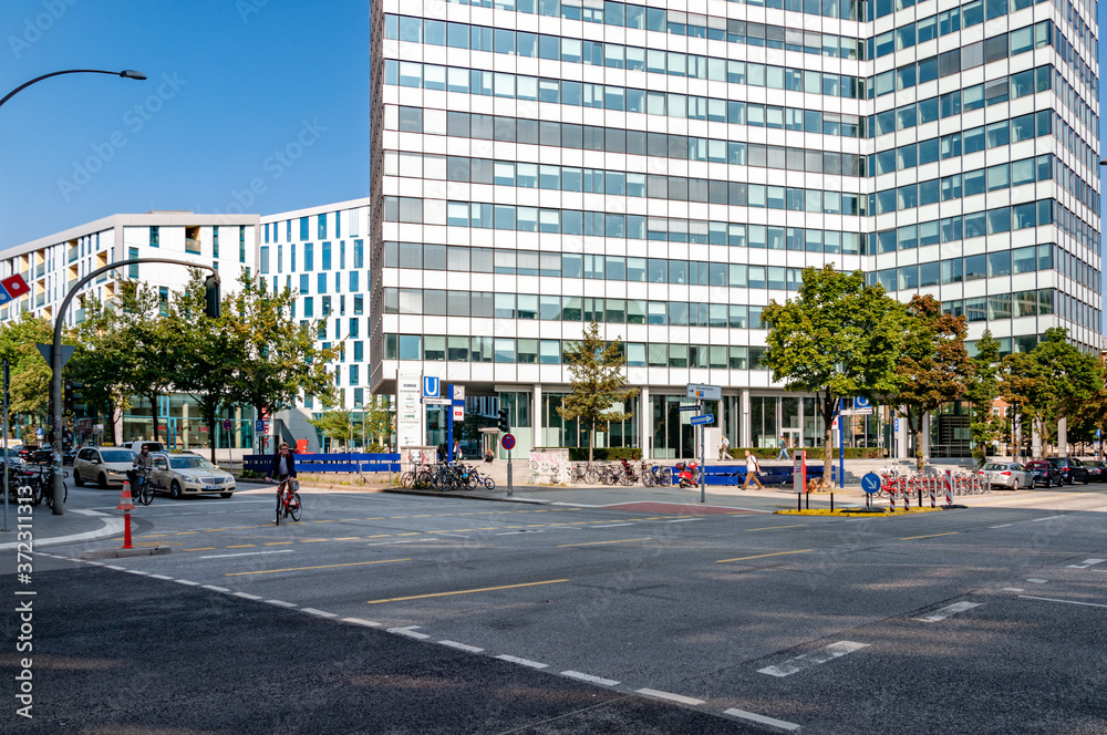 Street traffic in city. Cityscape with office building skyscraper and dotted line road marking on foreground Street traffic in city. Cityscape with office building skyscraper and dotted line road marking on foreground