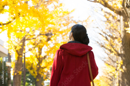 並木道を散歩する女性