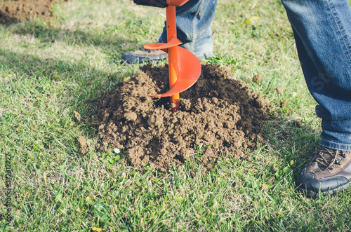 excavator machine digging hole into grass