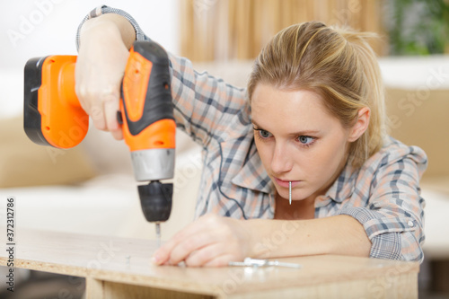 young woman using electric screwdriver photo