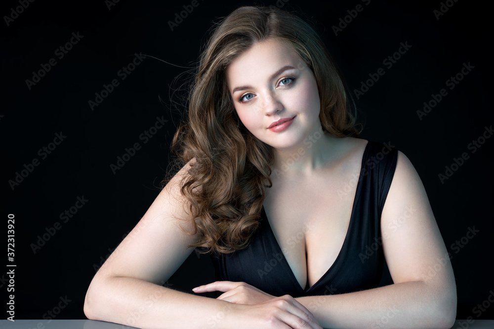 Young beautiful woman with natural makeup on black background. Beauty & Skin care concept. Plus size model.
