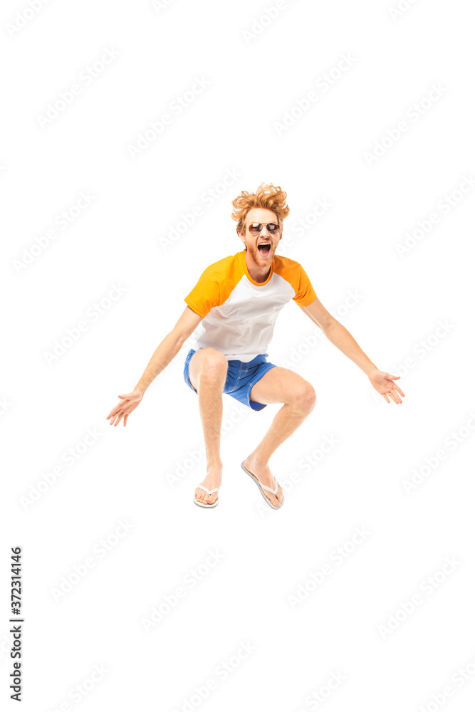 Excited man in flip flops and sunglasses jumping isolated on white