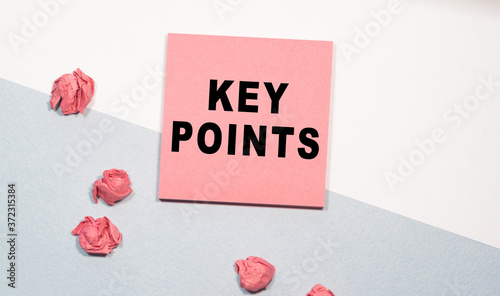KEY POINTS the inscription on the pink sticker, next to scattered crumpled papers. white-and-blue background. Business concept
