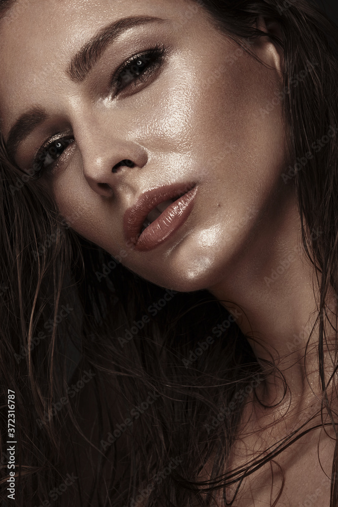 Beautiful girl with a bright make-up, wet hair and skin. Beauty face.
