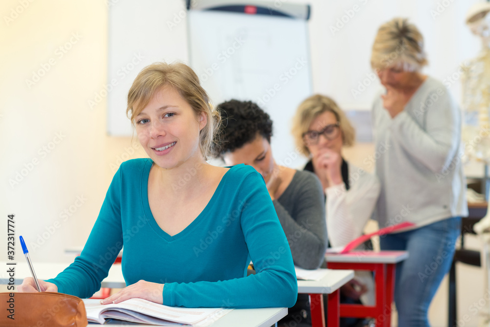 portrait of young adult sat at desk in classroom portrait of young adult sat at desk in classroom