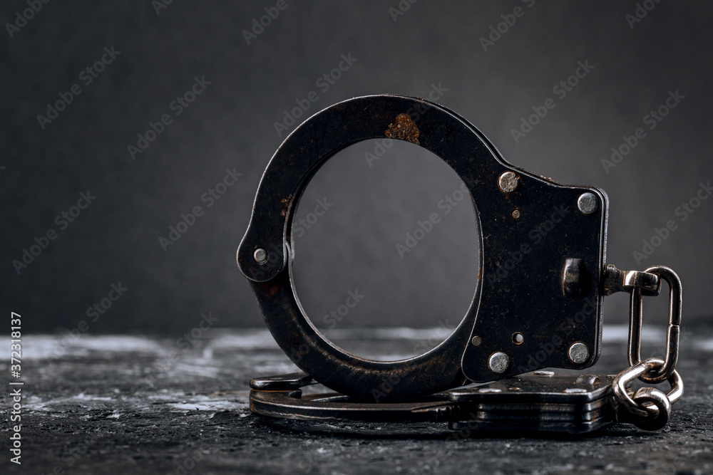 Obraz premium Handcuffs on a dark background. The concept of crime and police.