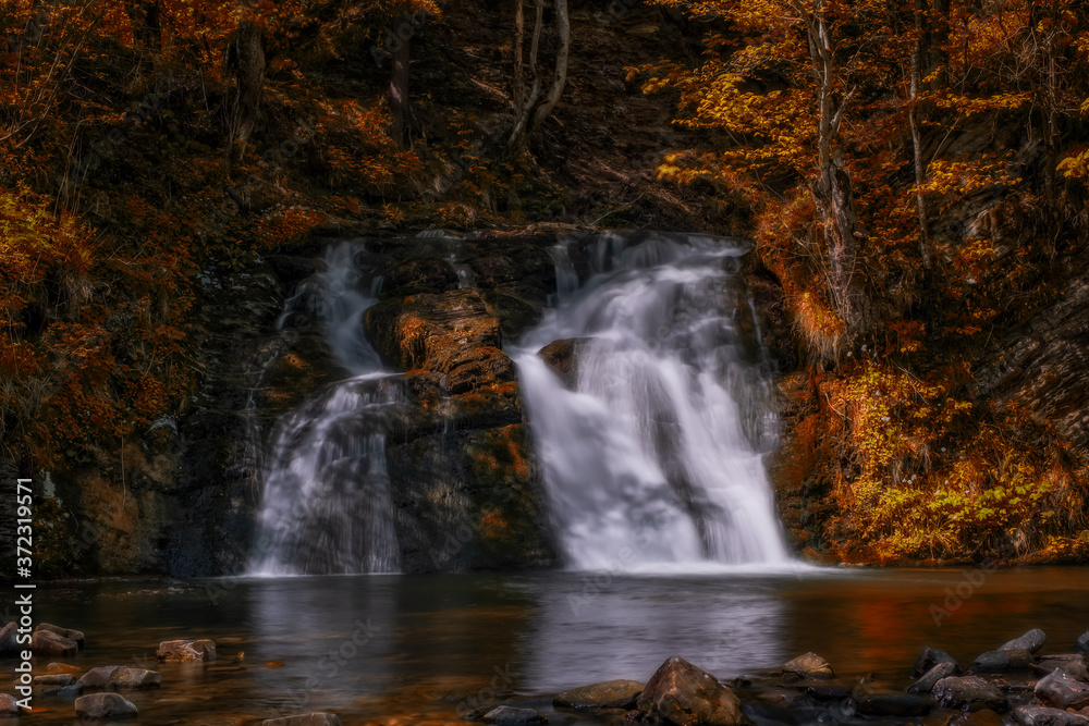 Fototapeta premium wonderful waterfall on the mountain river Carpathians. Gurkalo or Hurkalo Waterfall, Carpathian Mountains, National Park of Skole Beskydy, Ukraine. autumn 2020. Long exposure shot.