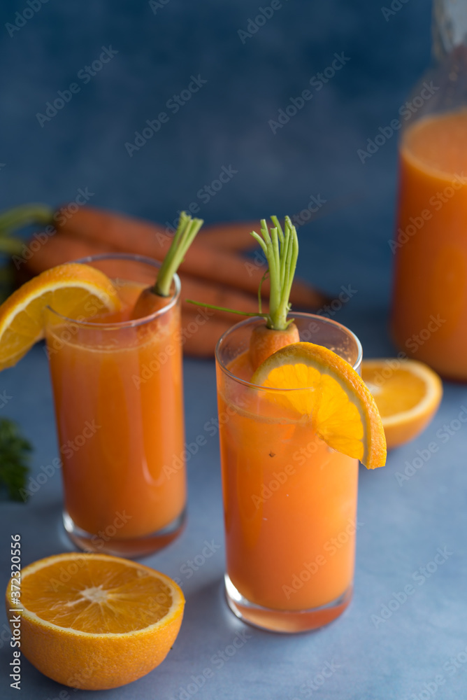 Fresh orange and carrot juice on blue background. Fresh orange and carrot juice on blue background.