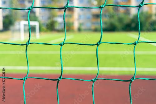 Close up of football soccer goal net and city school stadium background