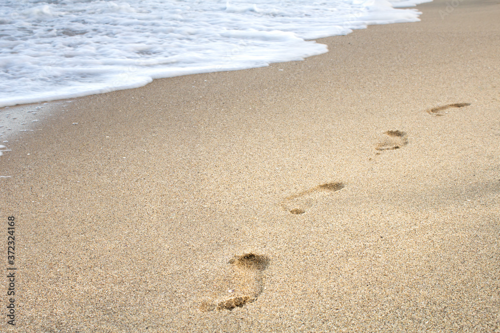 Steps in the sand with sea waves Steps in the sand with sea waves