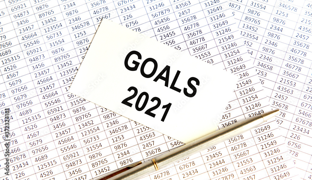 Obraz premium GOALS 2021 words written on a white piece of paper laid on a wooden table. Top view, concept in business.