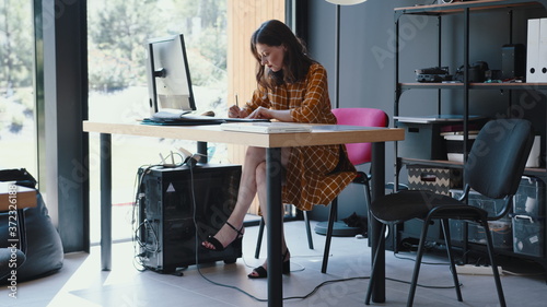 Beautiful happy 30s brunette European freelancer business woman working at modern coworking office table slow motion.