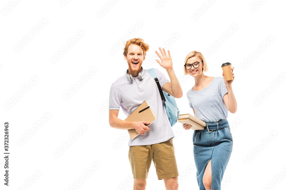 Fototapeta premium Students with books and coffee to go waving hand at camera isolated on white