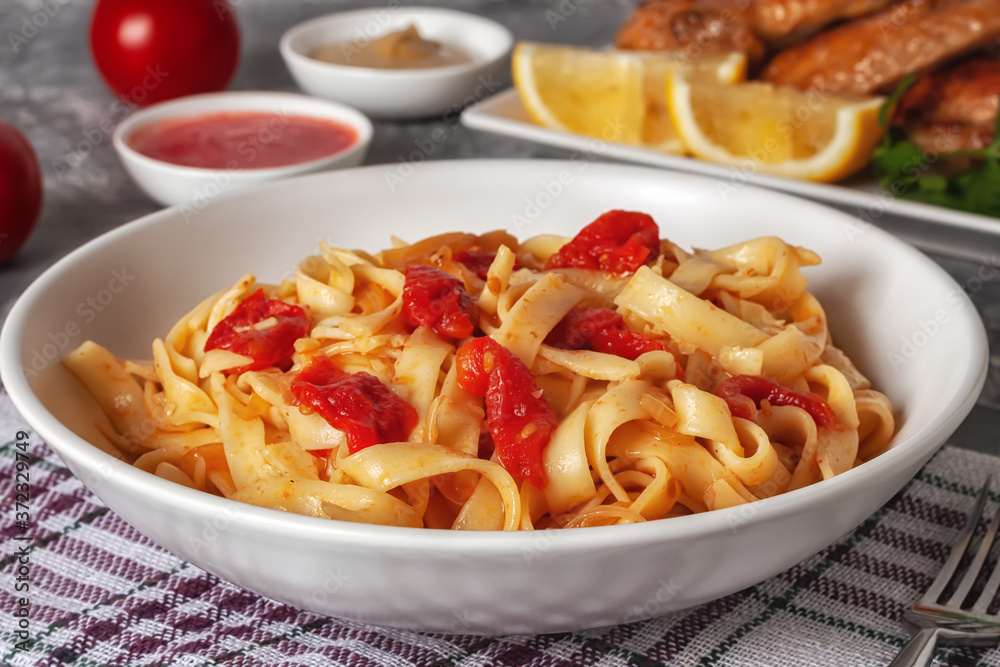Pasta with tomatoes and grilled wings. Italian food. Italian Cuisine. The concept of tasty and healthy food. Pasta with tomatoes and grilled wings. Italian food. Italian Cuisine. The concept of tasty and healthy food.