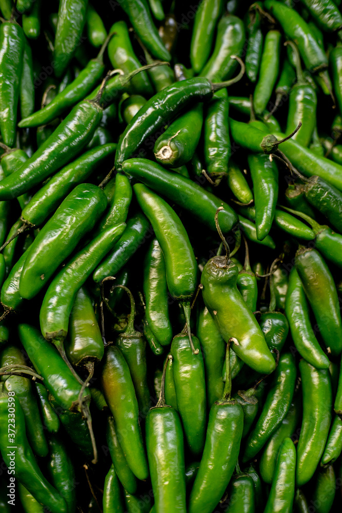 green tree chili peppers at a market stall green tree chili peppers at a market stall