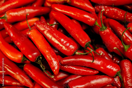 фотографія red serrano chili peppers at a market stall