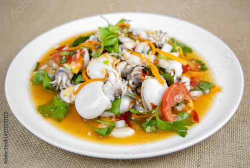 Thai Spicy Squid Salad on Burlap Fabric isolated