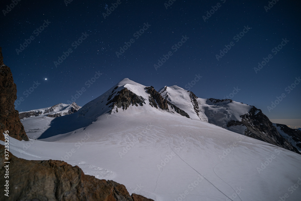 Night view of famous alpine peaks Castor and Pollux. Starry night over