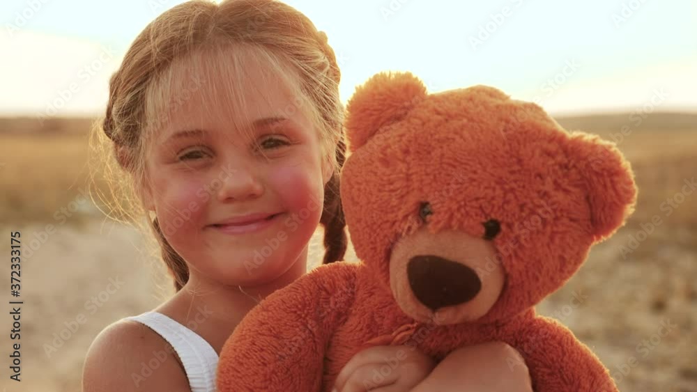 Vidéo Stock little kid girl hugging a teddy bear toy portrait in the ...