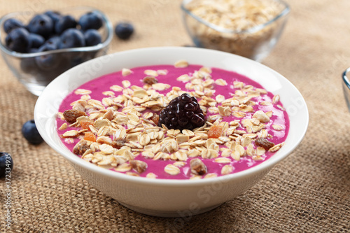 Breakfast bowl with cereals, fruit, oats, blueberries. Healthy morning meal on a wooden background. Top view.