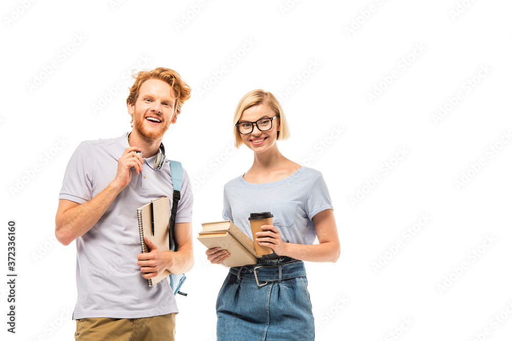 Students looking at camera while holding books, coffee to go and headphones isolated on white Students looking at camera while holding books, coffee to go and headphones isolated on white