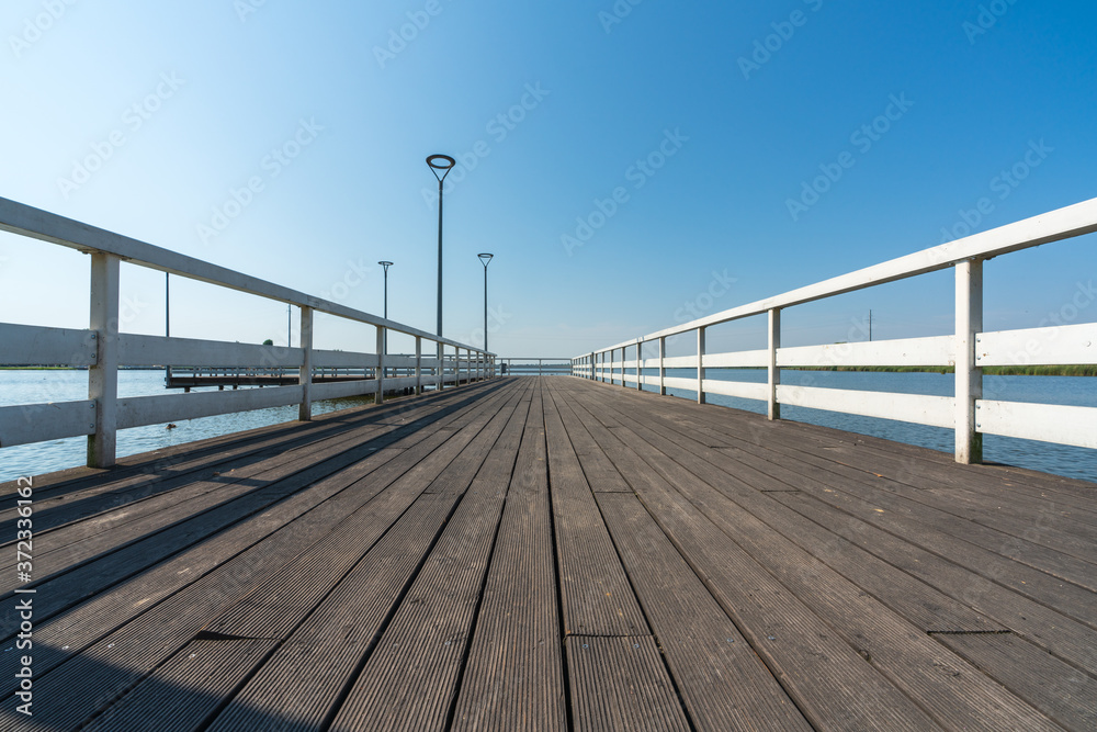 Fototapeta premium Pier on a small lake in the town of Znin on a sunny summer day