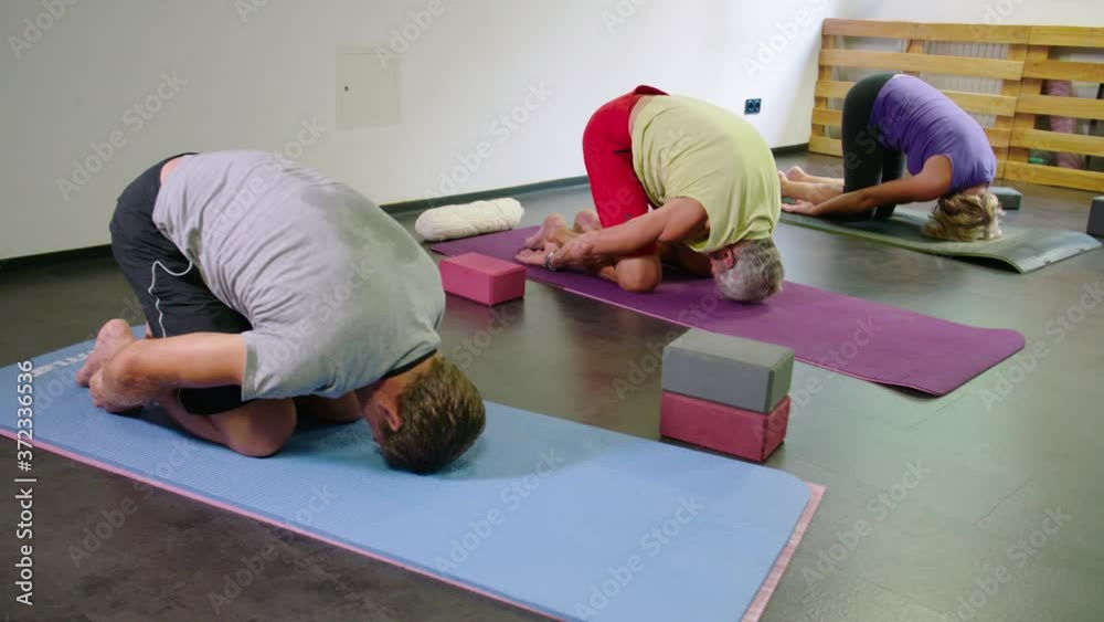 Yoga class in studio with female yoga teacher