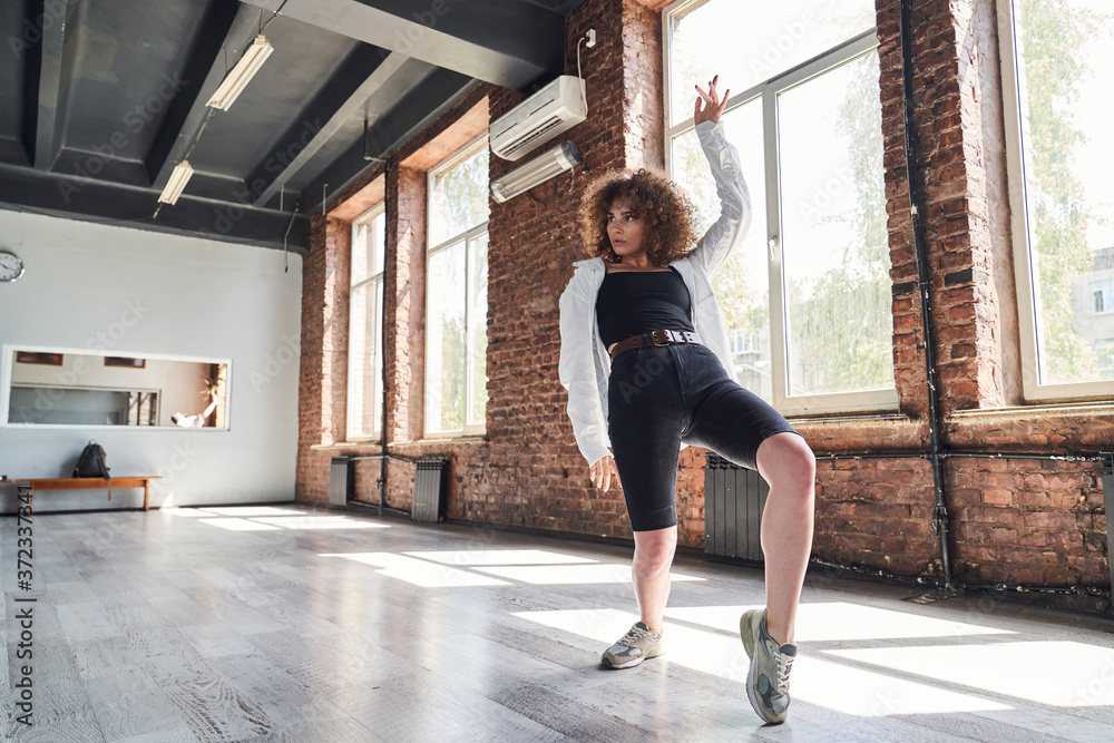 Graceful young woman dancing in sport studio