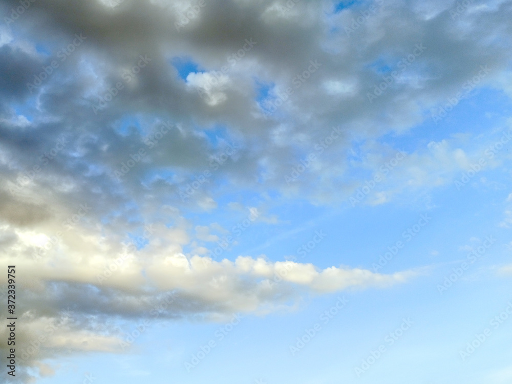 photo of blue sky with white and gray clouds on a summer evening