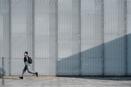 Business man running with backpack in the morning photo
