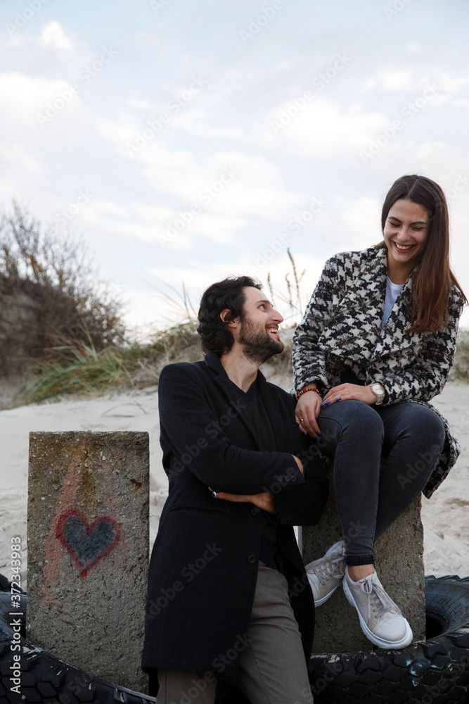 Content couple having fun while talking together at beach Content couple having fun while talking together at beach