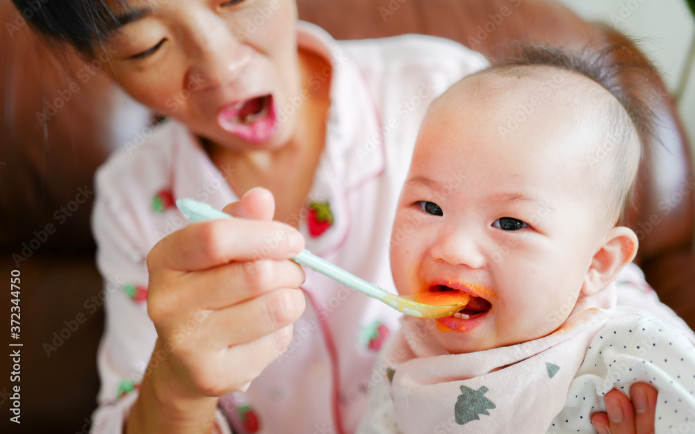Portrait of cute little baby girl with carrot puree on the mouth Portrait of cute little baby girl with carrot puree on the mouth