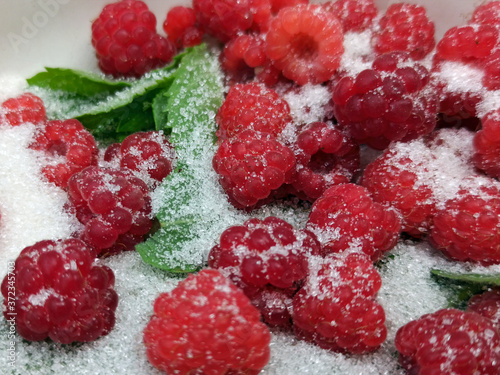 photo of raspberries and mint leaves with white sugar. ingredients for mojito. Top view