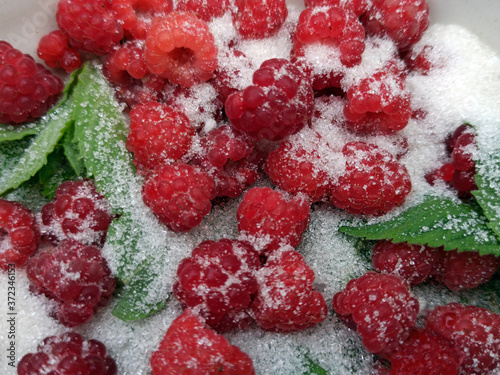 Obraz na płótnie photo of raspberries and mint leaves with white sugar. ingredients for mojito. Top view w salonie