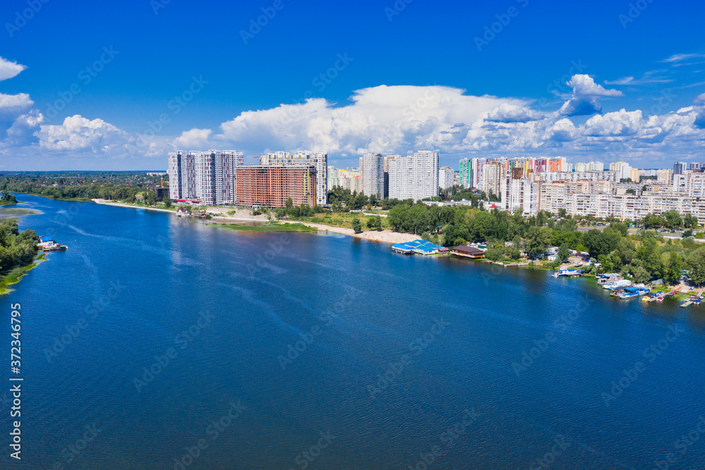 Panoramic View of the left bank of the Dnipro River in Kiev during the day against the blue sky and riverbed