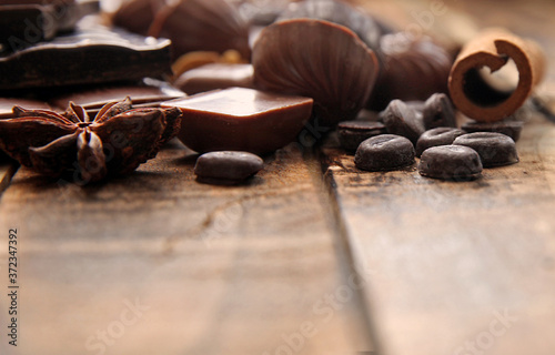 Dark chocolate pieces on a wooden table, copy space