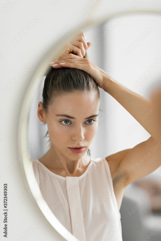 Portrait of young woman getting ready to go out home, in front of mirror, Minsk, Belarus. Portrait of young woman getting ready to go out home, in front of mirror, Minsk, Belarus.