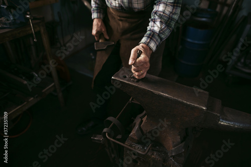 Mature man working in blacksmith shop.