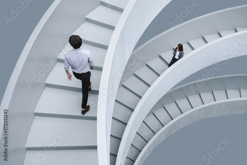 Businessman and businesswoman walking on office stairs