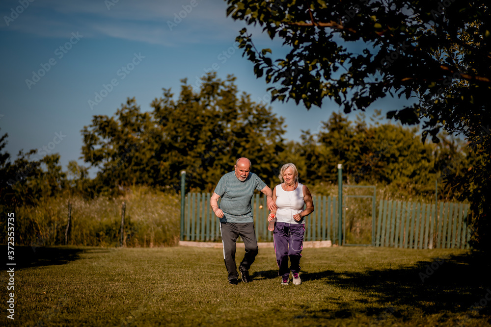 Senior couple running outside . Elderly man and woman jogging together Senior couple running outside . Elderly man and woman jogging together