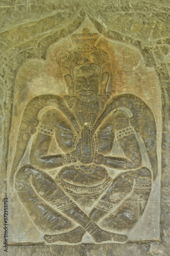 Bas relief carving of a man praying on a wall at Ankgor Wat UNESCO heritage site